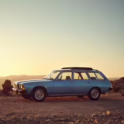 a blue car in the desert with the sun shining