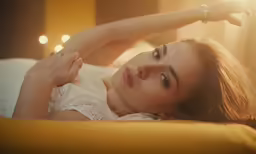 a young woman laying on a yellow pillow