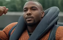 the man is wearing a grey seat belt while holding up his arm