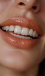 a womans lips are whitening with light orange lipstick