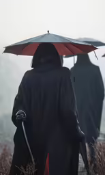 two people are walking outside on the side of a hill