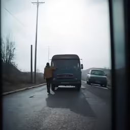 a man standing next to a bus on the road