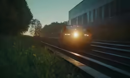 a car driving in a street between a train track and a building