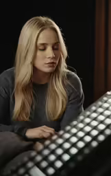 the blonde woman is sitting by the keyboard