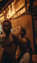 two people posing outside on a street at night