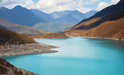 a long body of blue water with mountains in the background