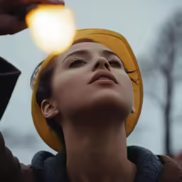 a woman holding her head up as she looks upward at the sun