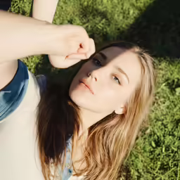 young woman in casual outfit looking up with head down