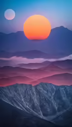 the mountain range is covered in misty fog with a bright orange sun above