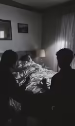 two people sitting on the bed while they are drinking a beverage