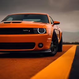 the front end of an orange sports car driving down a road