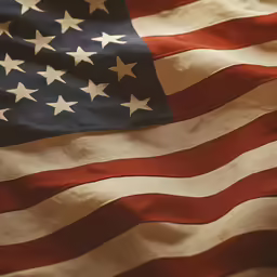 a large american flag waving in the wind