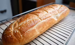 a long loaf of bread is sitting on a cooling rack