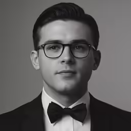 a man in a black suit with a bow tie