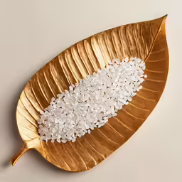 an intricate leaf shaped dish topped with white petals