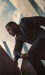a man in a suit leaning against the edge of a wall