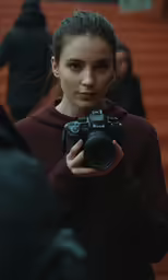 a woman with a camera in front of people