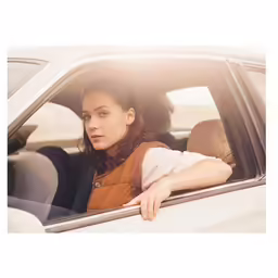 the woman is sitting in a car in the back seat
