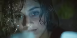 a girl with blue eyes is looking into the camera