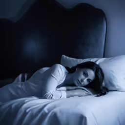 a woman posing on a bed in her night suit