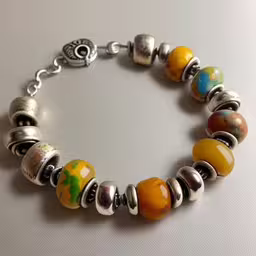a bracelet with many beads is shown,a bracelet with different colored charms hanging from it