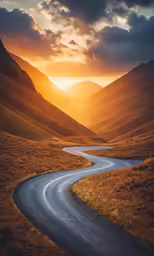 a winding road runs through the mountains at sunset