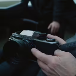 a person is holding an electronic camera in their hands