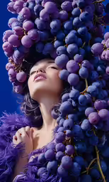 a woman with purple hair is surrounded by grapes