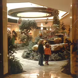 an older lady and child walking through a shopping mall,a woman and child standing in front of a store