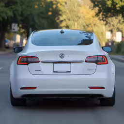 the rear view of a white car on the road