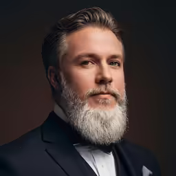 a man wearing a suit and bow tie poses for a photo