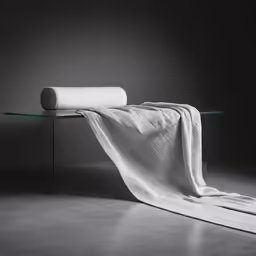 the towel is hanging on a glass table