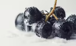 a pair of large plastic and rope covered black toy trucks
