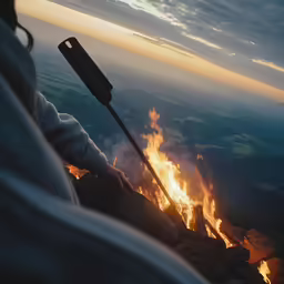 a woman holding an antenna while standing in front of a fire