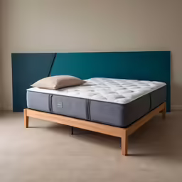 the side paneled mattress is on a platform next to a wall