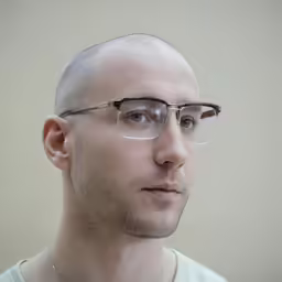 a man with glasses looking at the camera