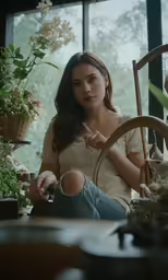 a woman sitting in front of some plants looking surprised