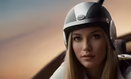 a woman in a helmet is sitting at a desk