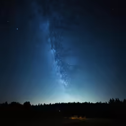 the night sky with a milky view and trees
