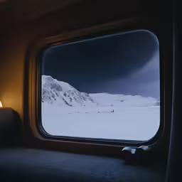 a window is looking out onto the snow covered mountains