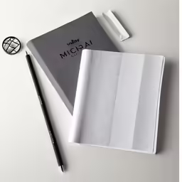 the back side of a notebook, pen and paper clip with mic cian printed on it