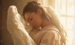 a young woman holding on to a white blanket