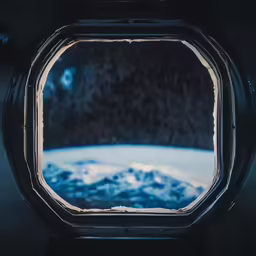 a port hole with snowy rocks in the distance
