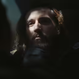 a man with long hair wearing a beard