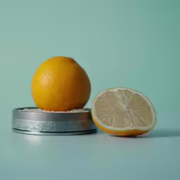 an orange is sitting in the middle of a plate with a lemon