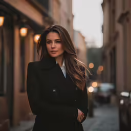 woman in black coat and white shirt in an old city alleyway