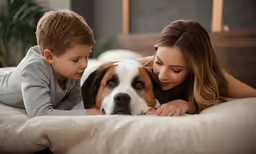 a woman and child lie next to a dog