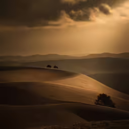 the sky has clouds and brown hills near one another