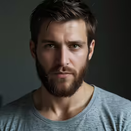 a bearded man is photographed in the dark