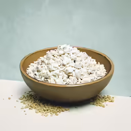 a bowl of white cereal is sitting on top of a table